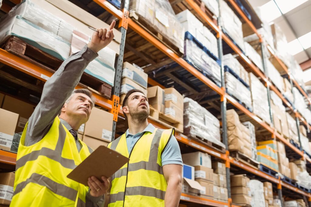 two men in warehouse pointing at inventory