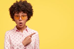 photo-shocked-woman-with-afro-haircut-holds-lips-curious-emotions-min